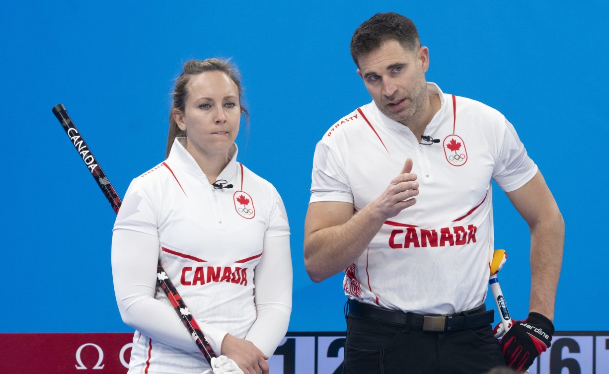 Rachel Homan and John Morris discuss a shot 