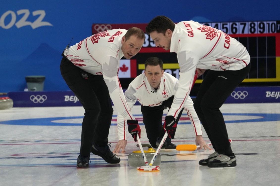 Team Gushue sweeps a shot thrown by Brad Gushue