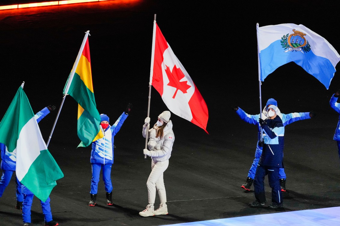 Isabelle Weidemann carries the Canadian flag in the closing ceremony