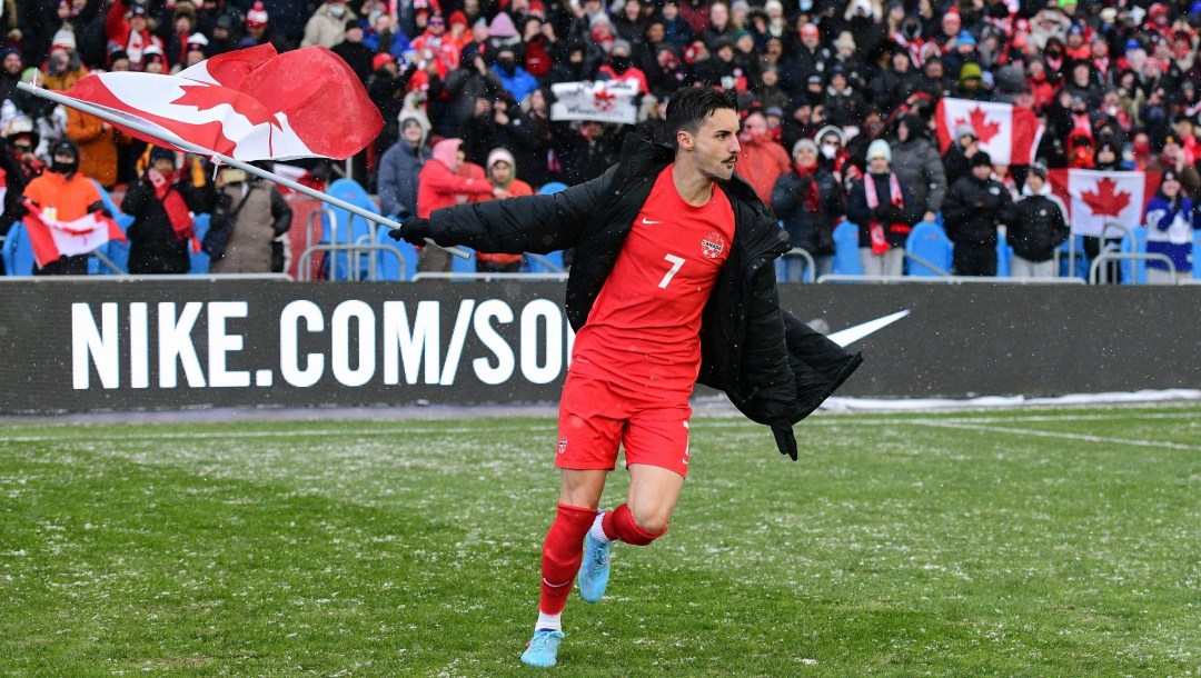 A member of Team Canada celebrates with a Canadian flag after defeating Jamaica
