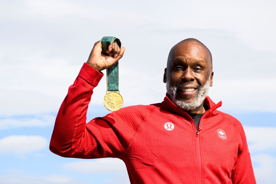 Bruny Surin holds up his Atlanta 1996 gold medal 
