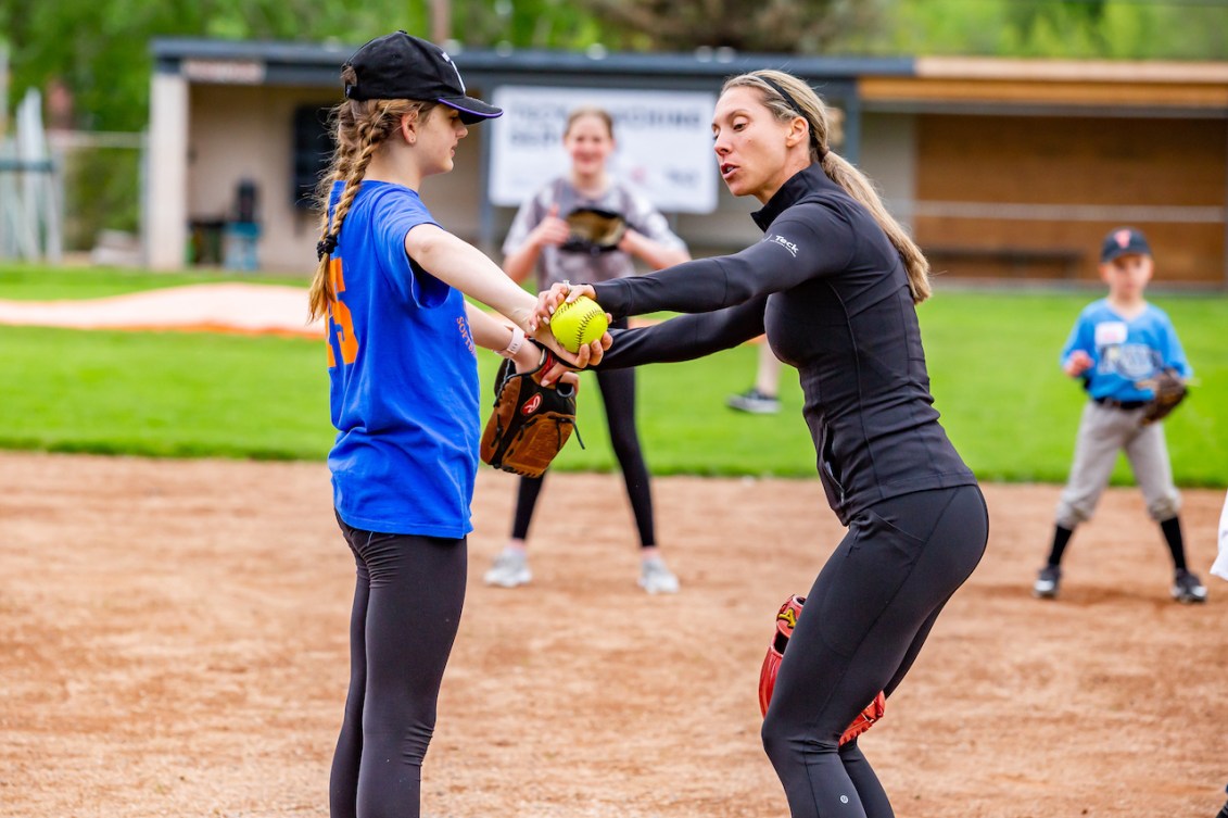 Lauren Regula shows a young pitcher how to position her arm 