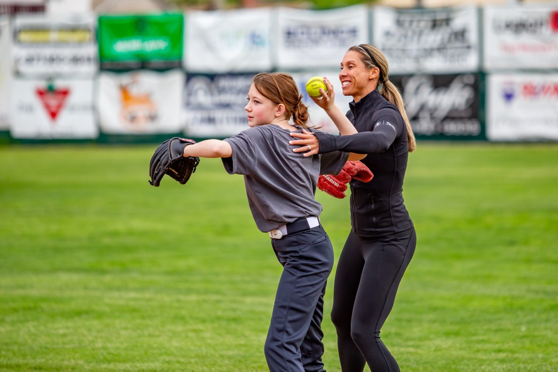 Lauren Regula shows a young player the right arm technique for pitching
