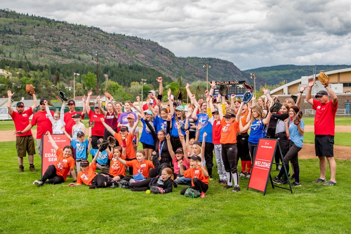 The youth and coach participants in Teck Coaching Series clinic pose on the field for the camera 