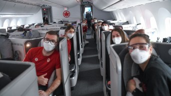 Athletes sit in their seats on an Air Canada flight