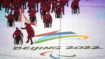 Team Canada walks into the Beijing 2022 Paralympic Opening Ceremony with the Games logo on the ground