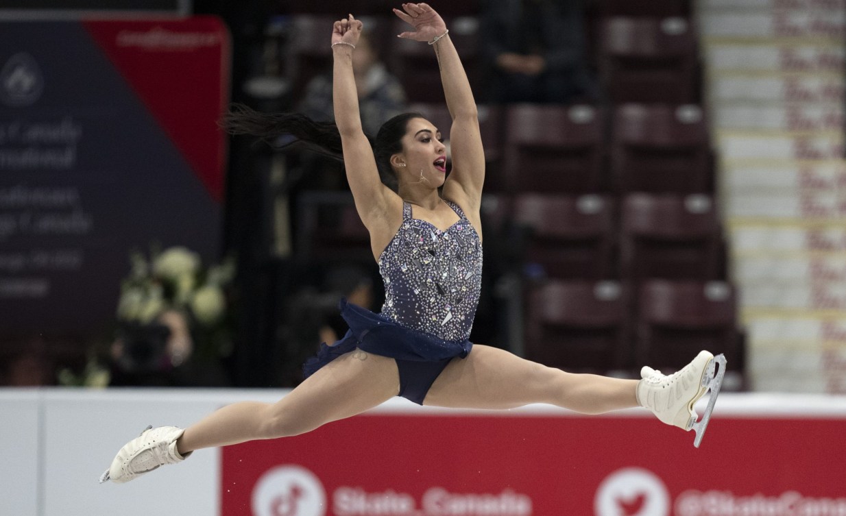 Gabrielle Daleman performs a split jump in a blue sparkly dress