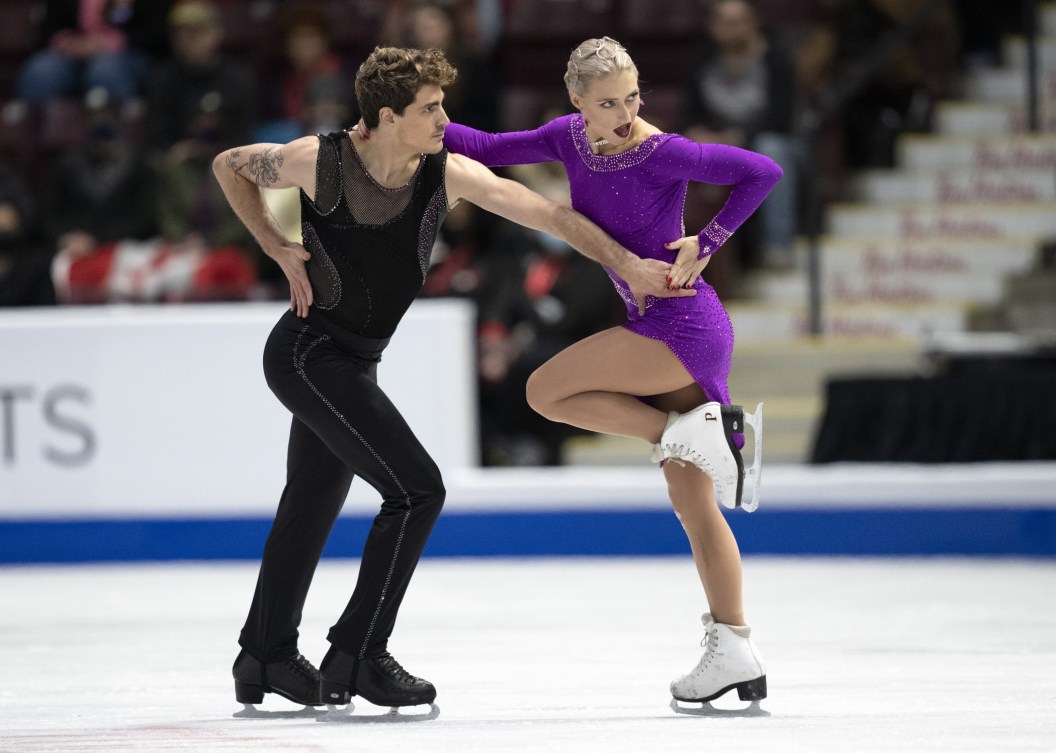 Piper Gilles and Paul Poirier dance on ice, her in a purple dress, he in black