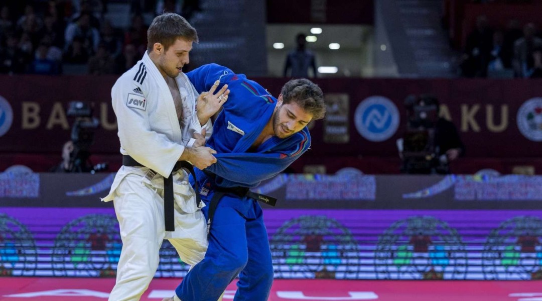 Arthur Margelidon in white faces his opponent in blue on the judo mat