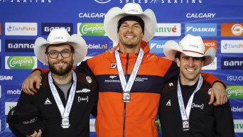 Hein Otterspeer, centre, of the Netherlands, celebrates his victory with second place finisher Canada's Laurent Dubreuil, left, and third place finisher Canada's Antoine Gelinas-Beaulieu on the podium following the men's 1000-metre competition at the ISU World Cup speed skating event in Calgary, Alta., Sunday, Dec. 11, 2022. THE CANADIAN PRESS/Jeff McIntosh