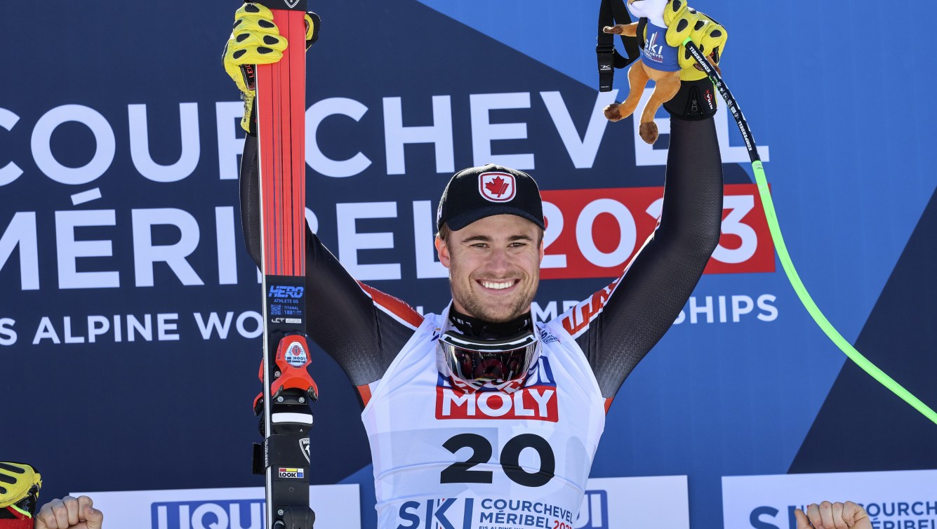 Cameron Alexander raises his arms in celebration on the podium