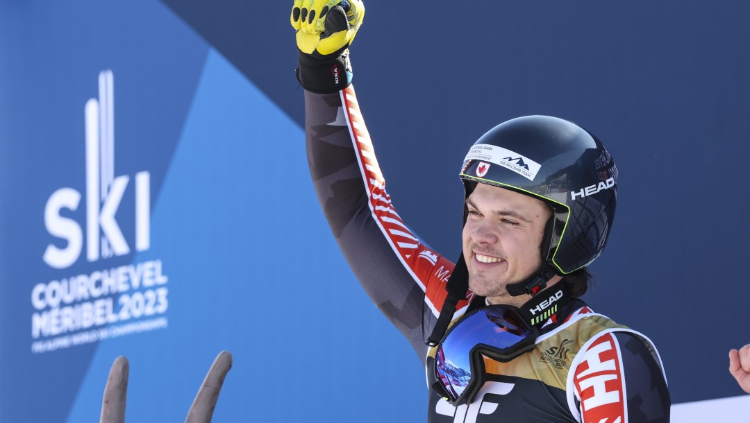 Jack Crawford raises his first in celebration while standing in the finish area of alpine skiing race