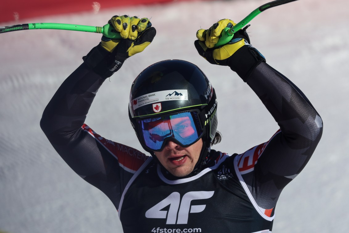 Jack Crawford raises his arms in celebration as he finishes his ski race