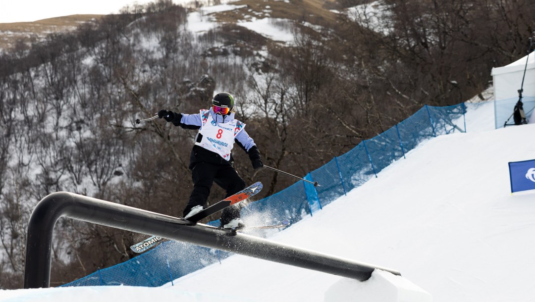 Megan Oldham skis along a big rail on a slopestyle course