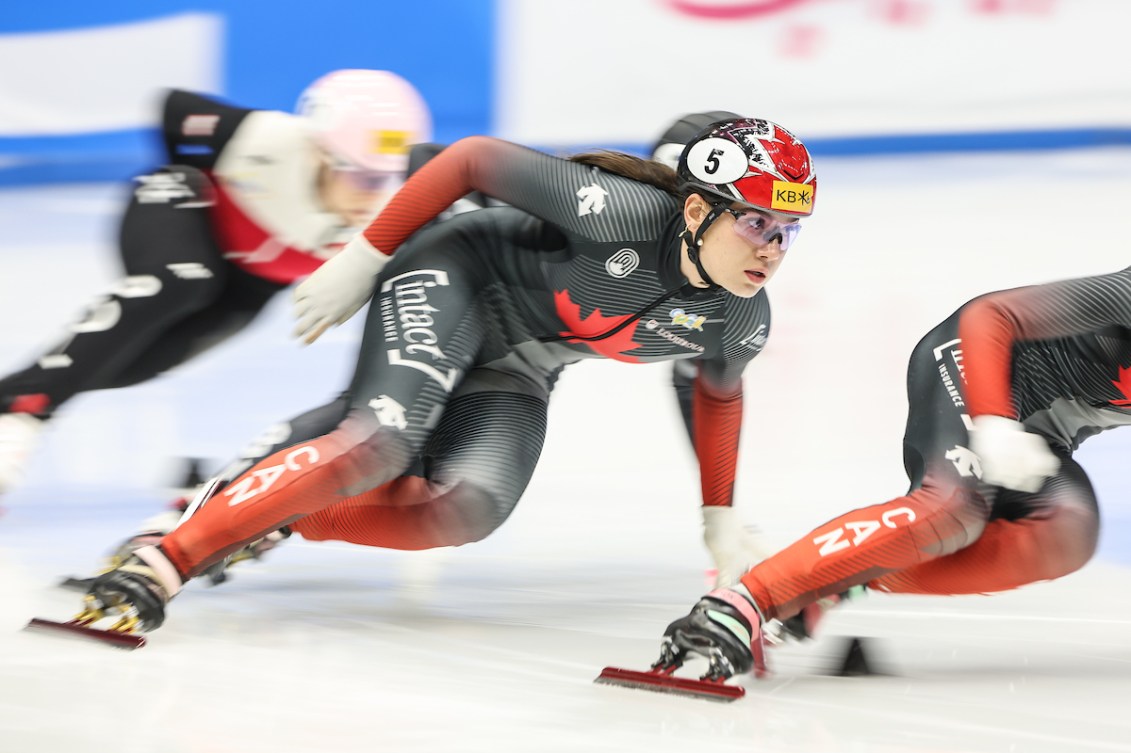 Courtney Sarault races around a turn in a short track speed skating race 