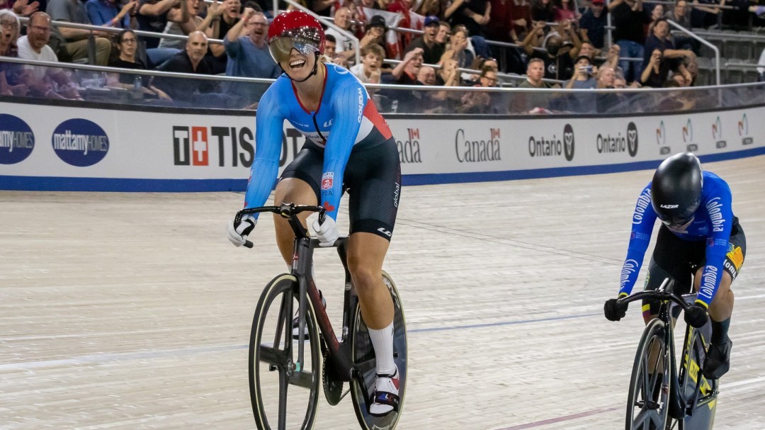 Two track cyclists react at the end of a sprint race, won by the Canadian in the light blue jersey