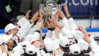 Team Canada players lift the trophy after winning the 2021 IIHF World Championship.