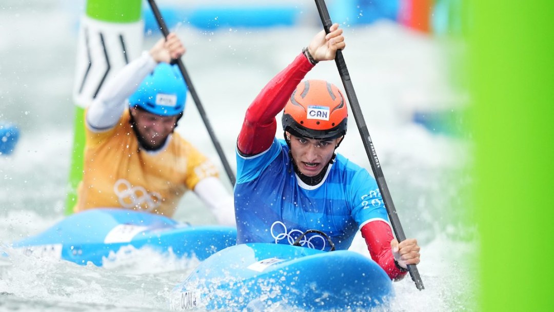 Alex Baldoni paddles while wearing a blue jersey and red helmet