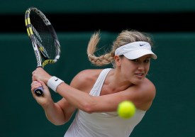 Eugenie Bouchard returns a shot while wearing white at Wimbledon