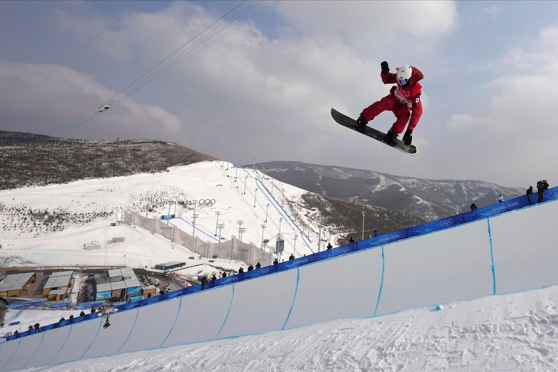 Liam Gill grabs his board as he performs a trick in a halfpipe 
