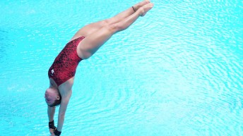 Mia Vallee enters the water head first after completing a dive in competition