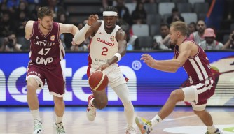 Canada guard Shai Gilgeous-Alexander (2) dribbles the ball against Latvia guard Arturs Kurucs (47) and guard Arturs Zagars (55) during the Basketball World Cup