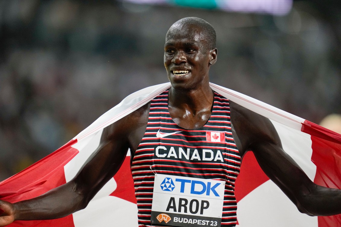 Marco Arop wears the Canadian flag around his shoulders.