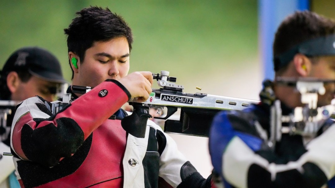 A shooter loads a bullet into his rifle