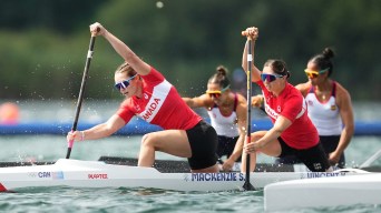 Sloan Mackenzie and Katie Vincent race while wearing red and white jerseys