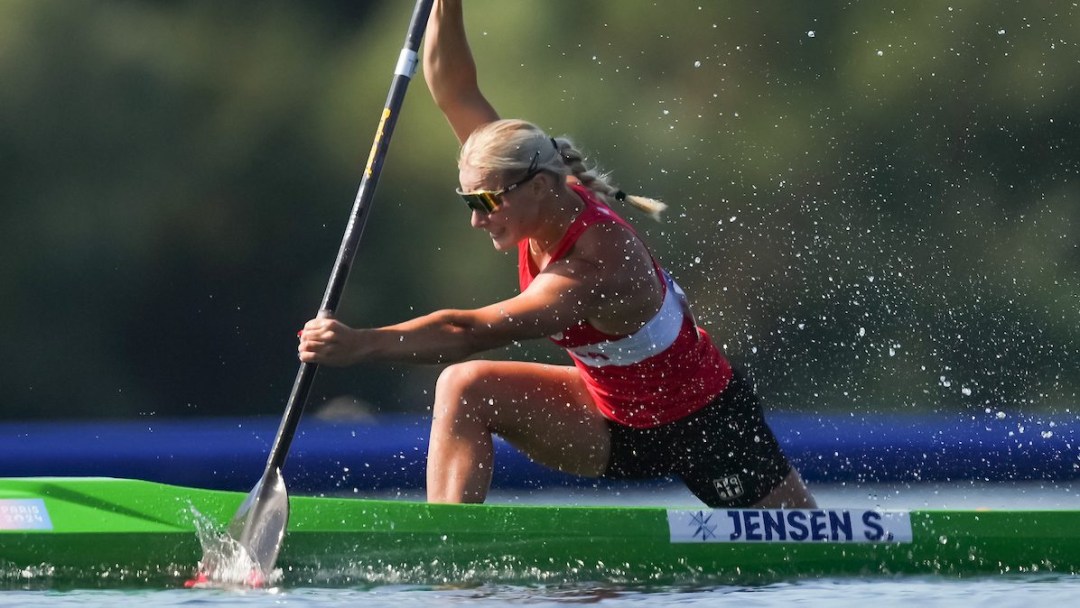 Sophia Jensen races in a green canoe