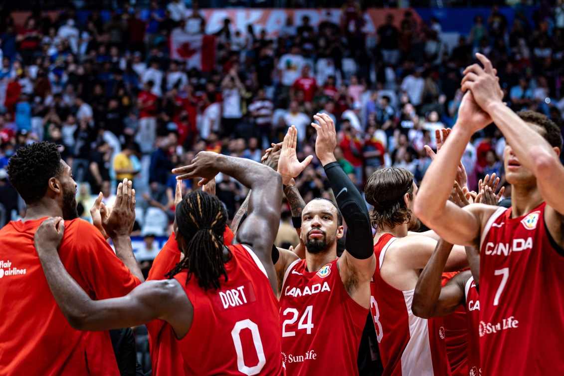 Canada's men's basketball team applauds with hands over their heads