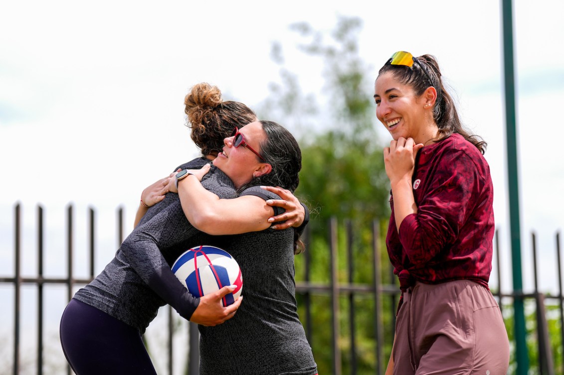 Chef de Mission Christine Girard hugs Brandie Wilkerson as Melissa Humana-Paredes looks on 