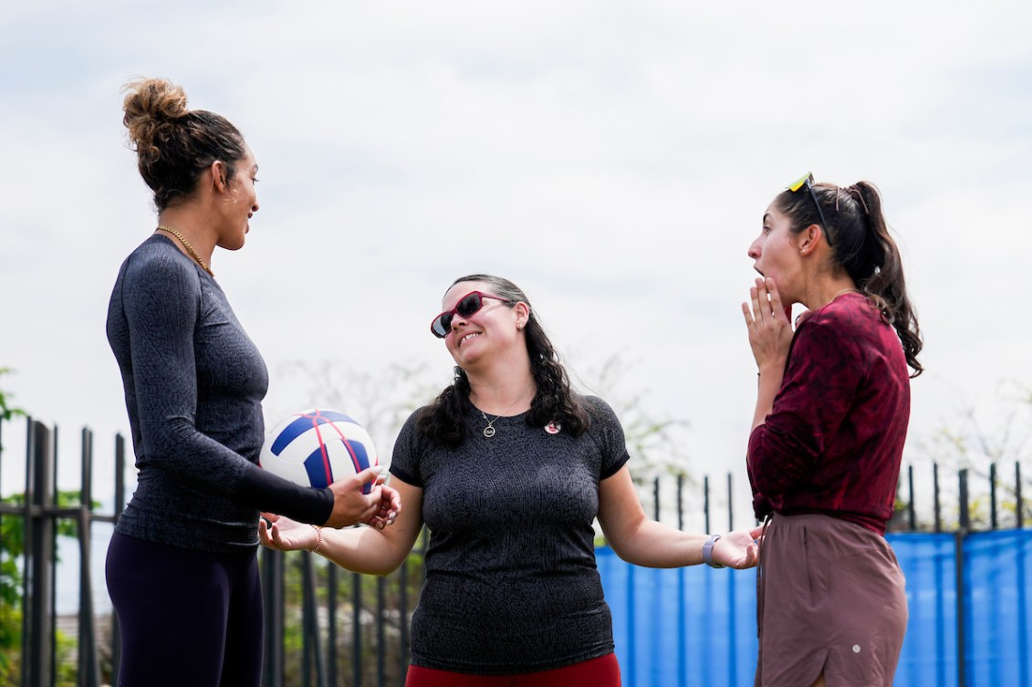 Brandie Wilkerson and Melissa Humana-Paredes react with shock to Chef de Mission Christine Girard telling them they are flag bearers