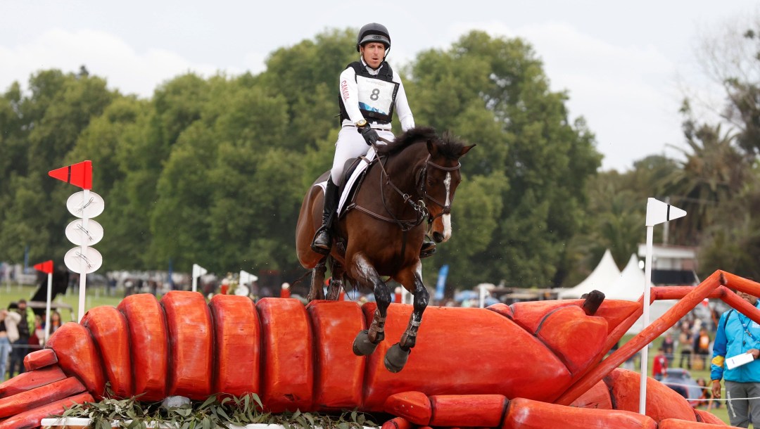 Michael Winter and his horse jump over a giant obstacle shaped like a lobster