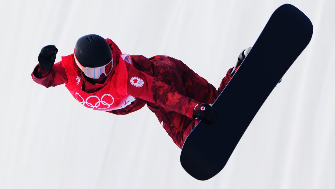 A female snowboarder does a flip while represnting Team Canada