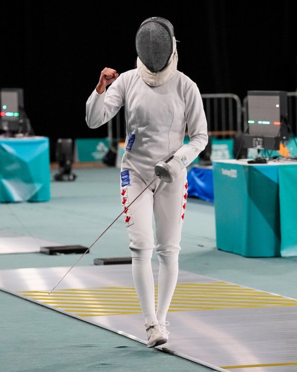 Ruien Xiao pumps her fist while wearing her fencing gear