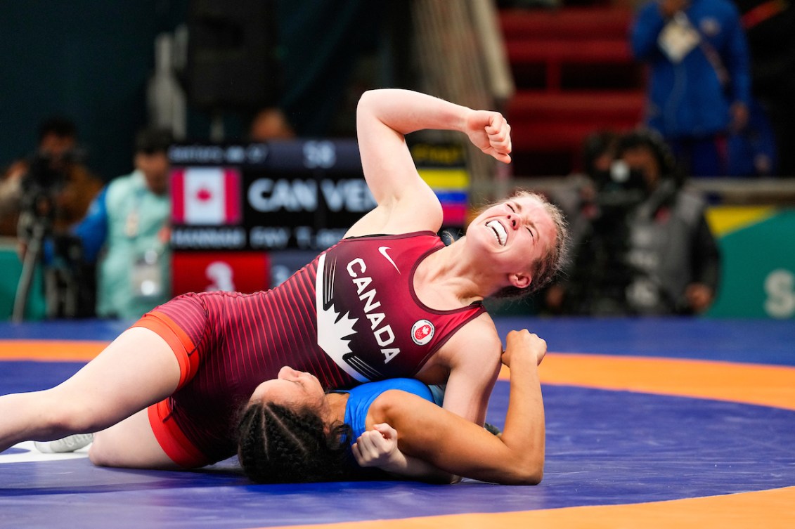 Hannah Taylor pumps her fist as she pins her opponent to the mat