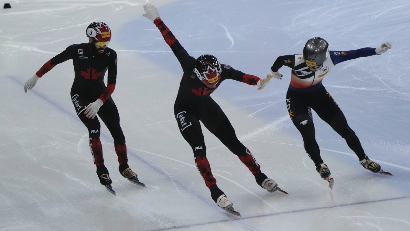 William Dandjinou, center, of Canada and Park Ji-won, right, of South Korea cross the finish line during the final of the men's 1,500-meter (2) at the ISU World Cup Short Track Speed Skating Championships in Seoul, South Korea, Sunday, Dec. 17, 2023. (AP Photo/Ahn Young-joon)