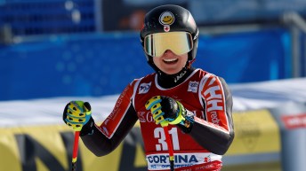 Val Grenier smiles while wearing a red ski suit, helmet and goggles