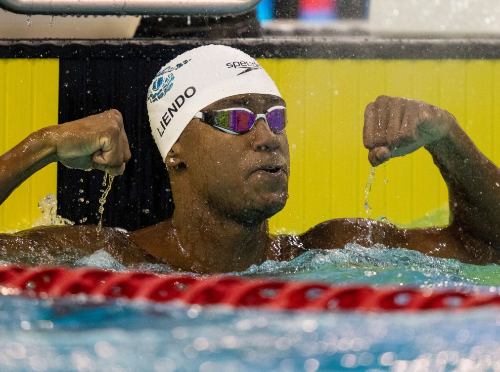 Josh Liendo pumps both his fists at the end of the pool