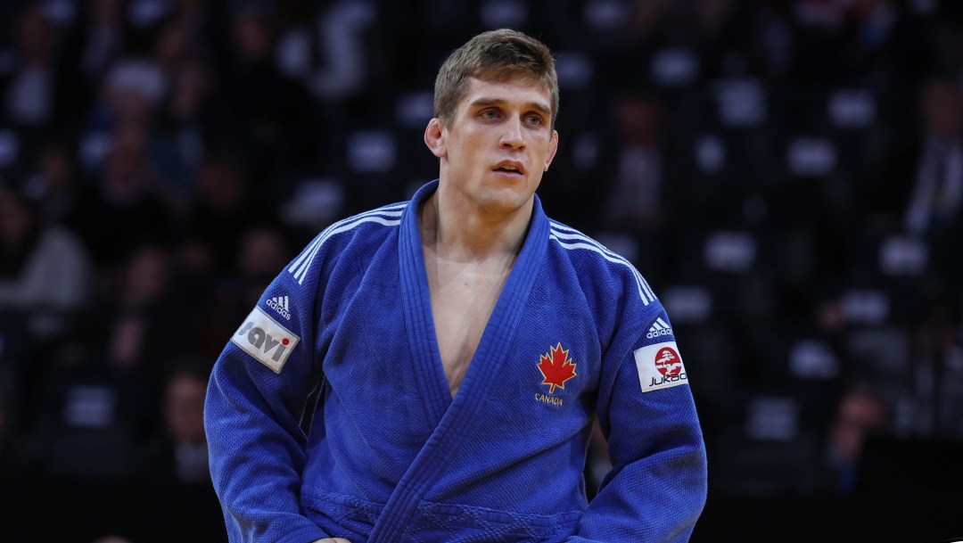 Francois Gauthier Drapeau in a blue judo outfit holds his hands on his hips