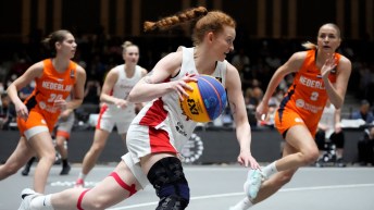 Kacie Bosch dribbles the ball while running down the basketball court