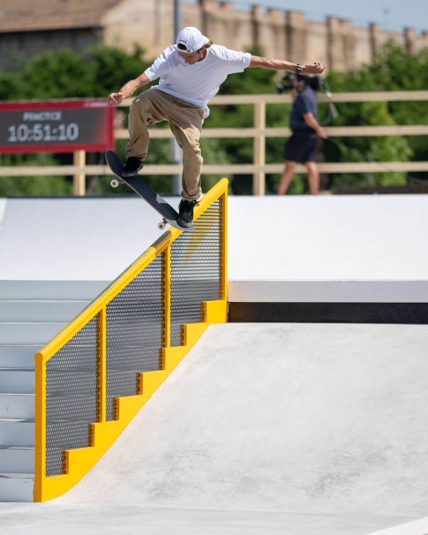 Skateboarder Ryan Decenzo hovers above a yellow railing