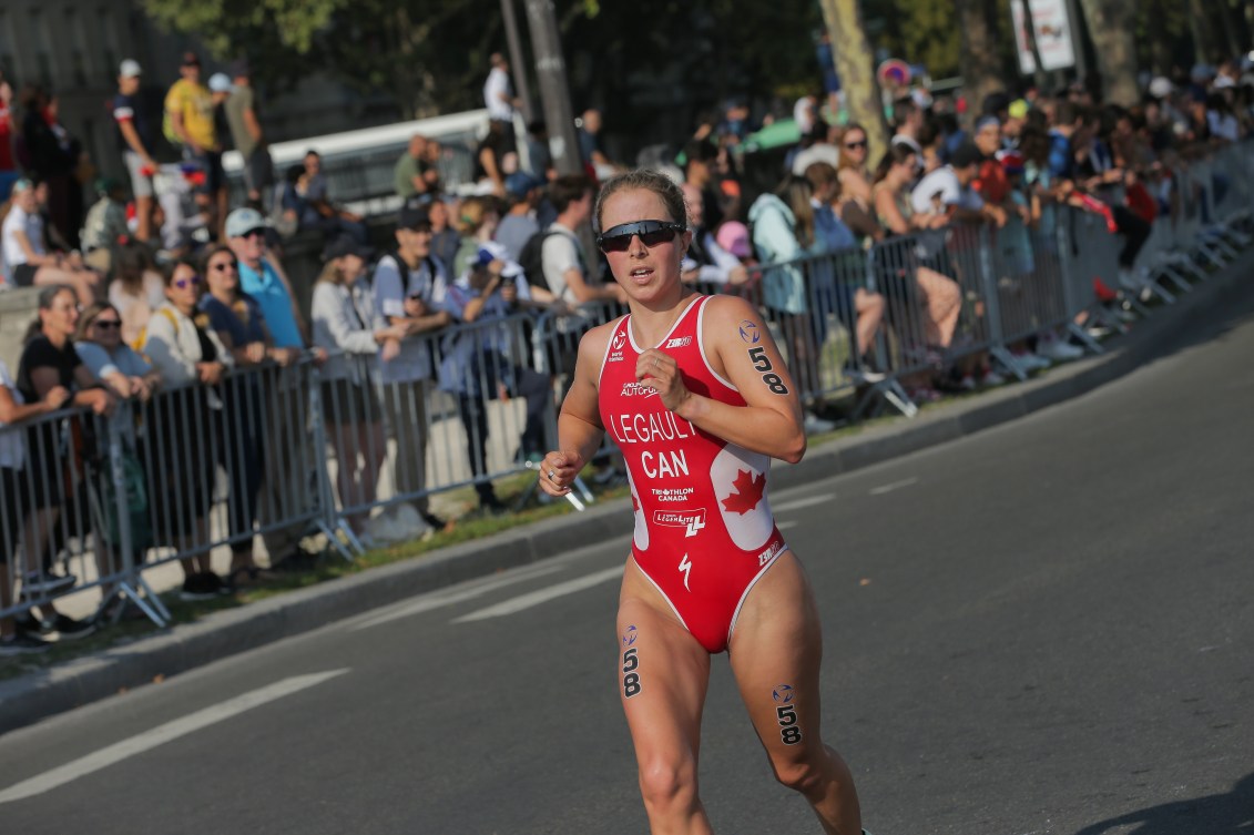 Triathlete Emy Legault runs while wearing a red bathing suit