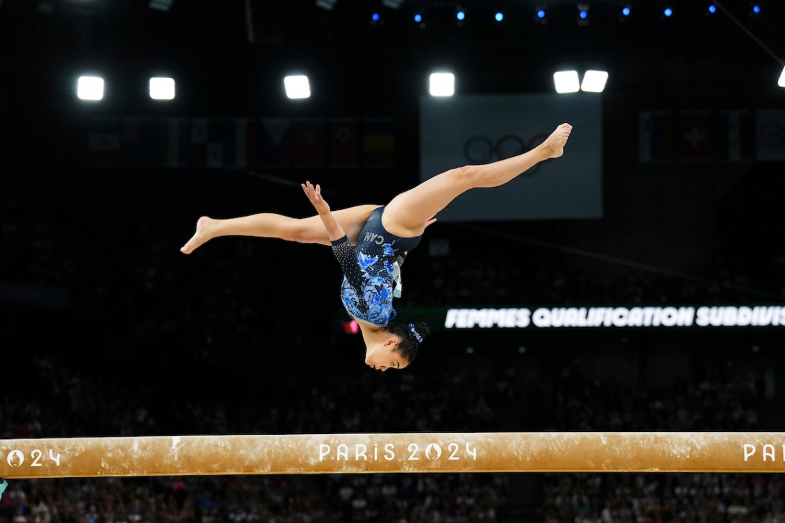Auerlie Tran does an upside down split leap on the balance beam