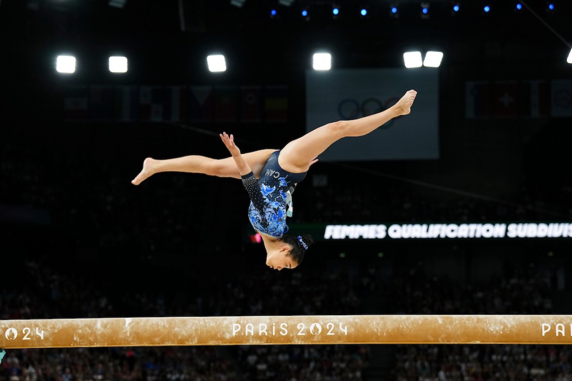 Auerlie Tran does an upside down split leap on the balance beam 