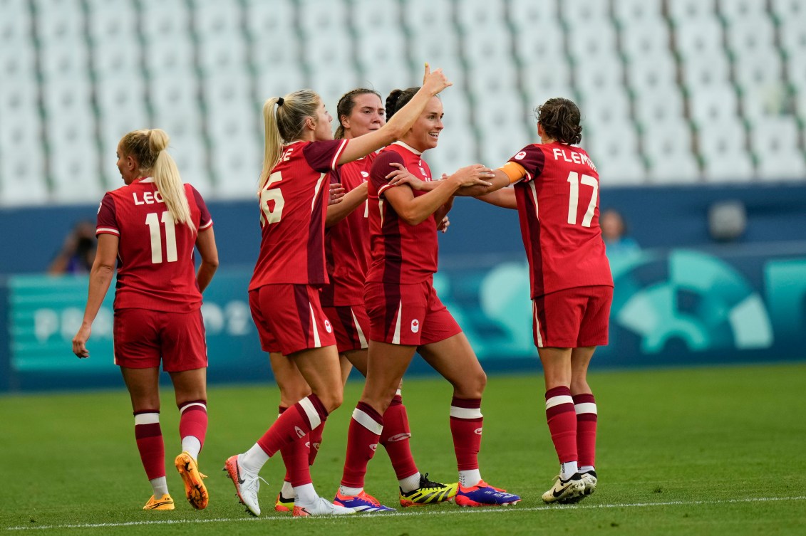 Team Canada players celebrate the winning goal from Evelyne Viens.