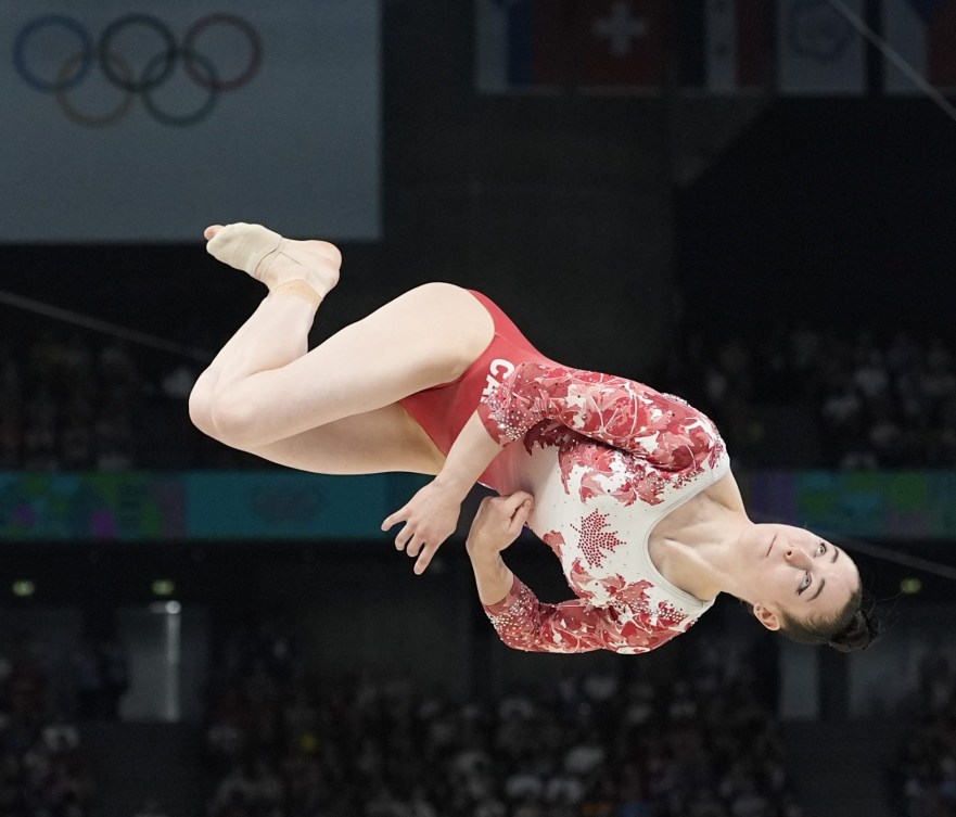 Ava Stewart performs a flip above the balance beam