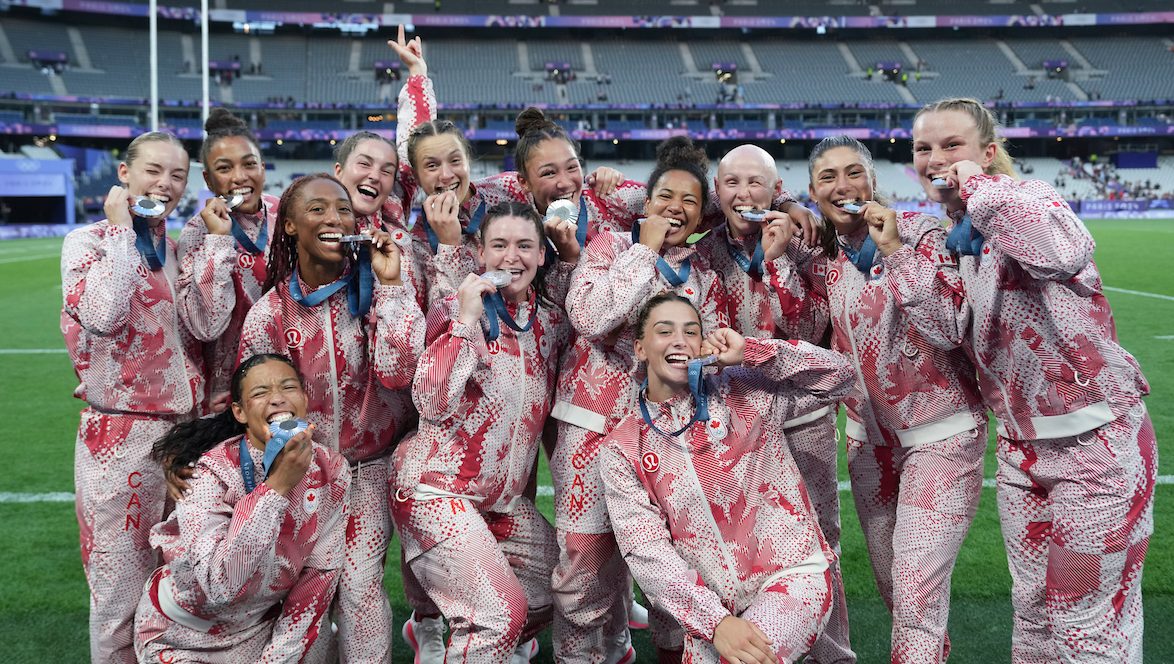 The members of the Canadian women's rugby team bite their silver medals