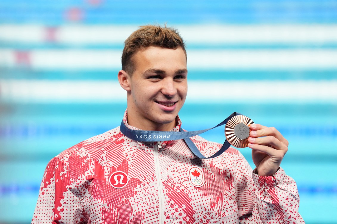 Ilya Kharun holding his silver medal